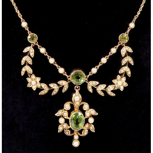 391 - An Edwardian 15ct gold necklace set peridots with seed pearl set flower and leaf surrounds, 11.3g, (... 