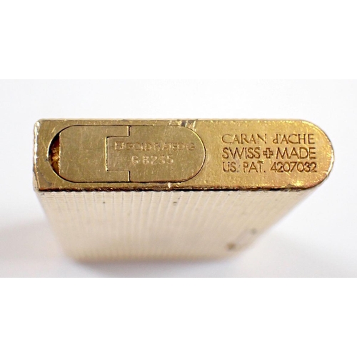 834 - A Caran D'ache gold plated lighter with applied crest