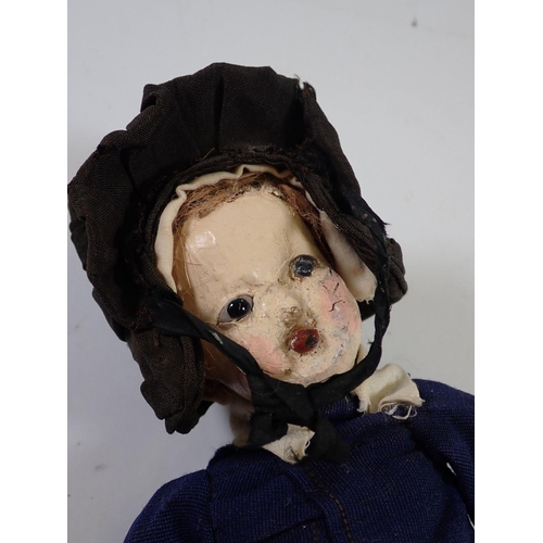 923 - An early papier mache head doll with wooden hands and legs, original costume, 32cm long