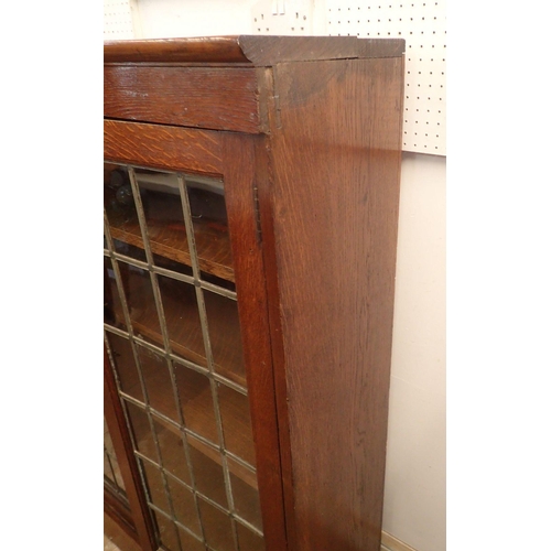 977 - An early 20th century oak lead glazed dwarf bookcase with three doors enclosing shelves, 156cm wide ... 