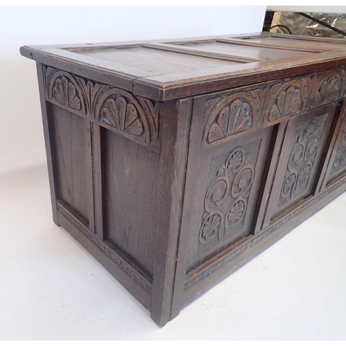 991 - An 18th century oak coffer with carved three panel front, 124cm wide approx