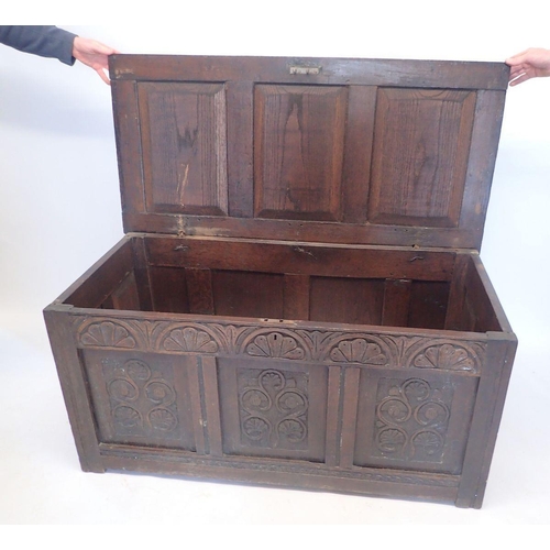 991 - An 18th century oak coffer with carved three panel front, 124cm wide approx