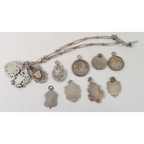 304 - A silver fancy link fob chain and eleven silver fobs and medals