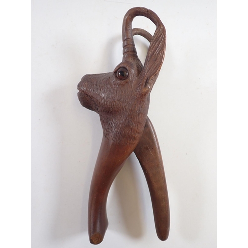 1041 - A Black Forrest novelty carved wood deer nut craker with glass eyes, 21cm