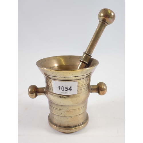 1054 - An antique brass pestle and mortar, 11cm tall