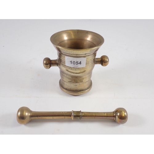 1054 - An antique brass pestle and mortar, 11cm tall