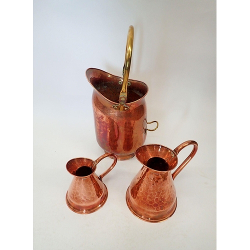 1065 - A copper coal scuttle 37cm tall and two copper ewers