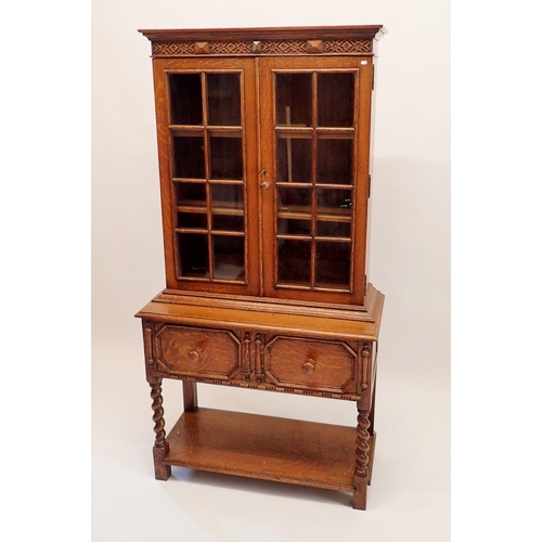 1066 - An early 20th century bookcase of very small proportions with two glazed doors over drawer all raise... 