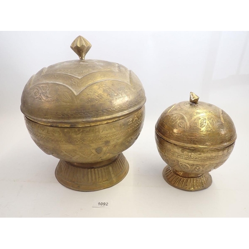 1092 - Two Nigerian 'Bida' brass embossed circular food boxes, largest 30cm tall