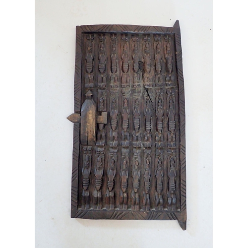 1102 - A carved Dogon tribal door, thought to be from a granary grain store in Mali, decorated three rows o... 