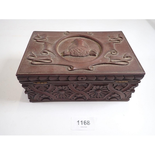 1168 - An antique carved wood box with bulls head to top and floral strap work, 18 x 12cm