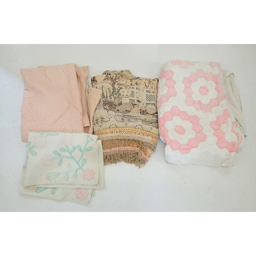 1311 - A pink and white patchwork quilt, a hand stitched pink Durham quilt, a machine made tasseled throw a... 