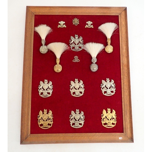 1319 - A framed display of seven Royal Artillery helmet plates, four hackles and four cap badges (Please no... 