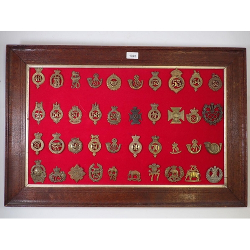 1322 - A framed display of forty numbered regimental military cap badges (Please note - some badges may be ... 