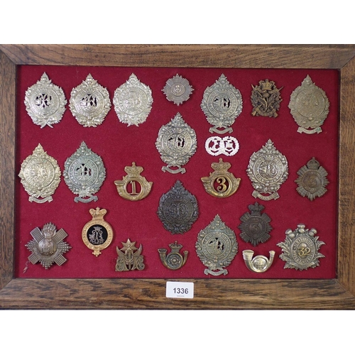 1336 - A framed display of twenty four military cap badges including examples of Argyle and Sutherland Regi... 