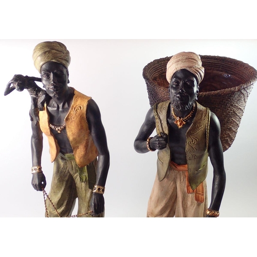 1379 - Two large African Indian decorative resin figures, man with monkey and cage and man with fruit baske... 