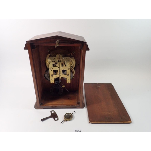 1394 - A 19th century mahogany mantel clock with arch top and enamel dial with pendulum and key, 31cm tall