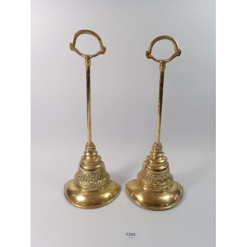 1399 - A pair of Georgian brass door stops or porters of bell form