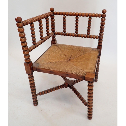 1429 - An Arts & Crafts William Morris style bobbin turned corner chair with rush seat