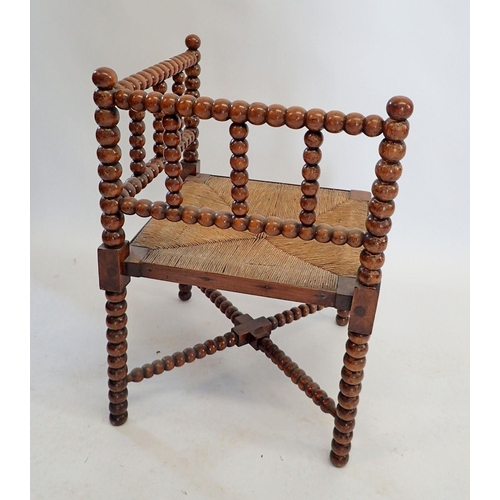 1429 - An Arts & Crafts William Morris style bobbin turned corner chair with rush seat