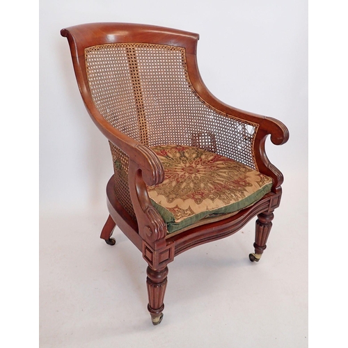 1457 - An early Victorian mahogany and cane library chair with scroll over arms on reeded supports