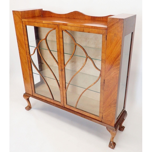 1483 - A 1950's walnut two door display cabinet with shell display bars, 119cm wide x 31cm deep