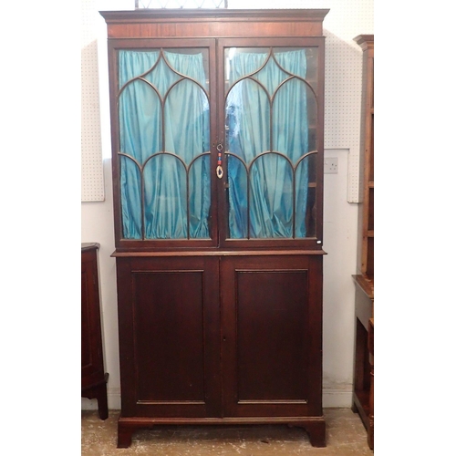 1494 - A Regency mahogany bookcase with two Gothic arch glazed doors over panelled cupboard, all on bracket... 