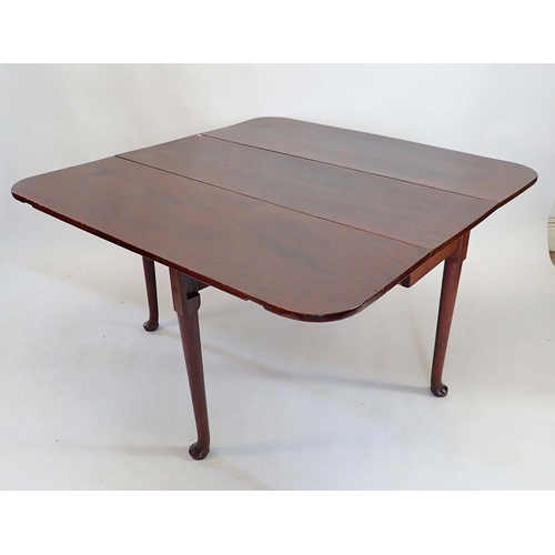 1502 - A Georgian mahogany dropleaf dining table on cylindrical supports and pad feet, 122 x 127cm