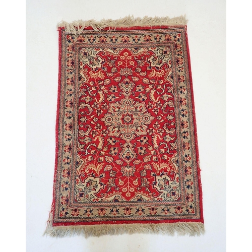 1504 - A small Persian style rug with floral medallion on red ground, 96 x 66cm