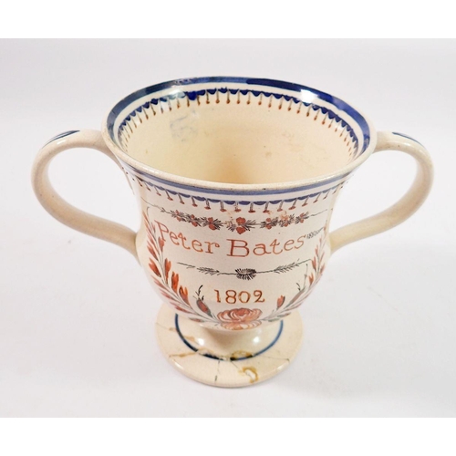 189 - An early 19th century creamware loving cup with glazed annotation 'Peter Bates 1802' and surprise fr... 