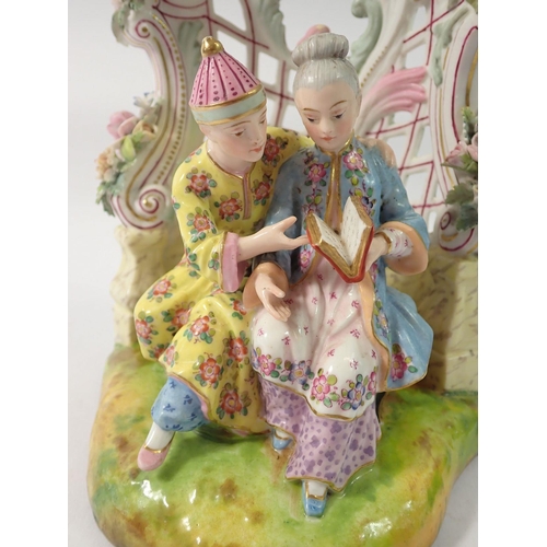 211 - A 19th century Meissen style group of Chinese couple seated reading in floral and scrollwork bower, ... 