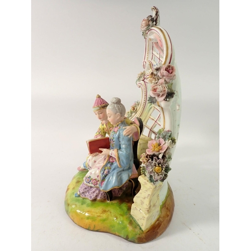 211 - A 19th century Meissen style group of Chinese couple seated reading in floral and scrollwork bower, ... 