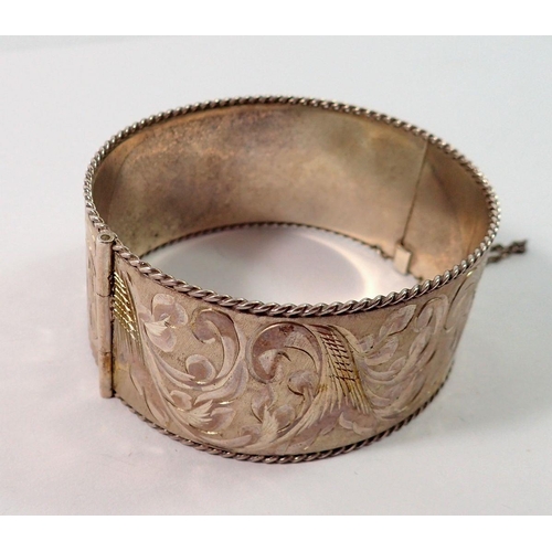 667 - A silver engraved hinged bangle with feature hallmark, Birmingham 1978, 62g