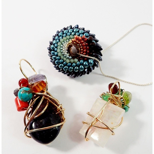 668 - Two yellow metal wire and stone studio jewellery pendants, largest 6cm and a beaded shell pendant on... 