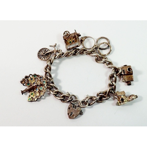 671 - A silver charm bracelet with silver and white metal charms, 48g