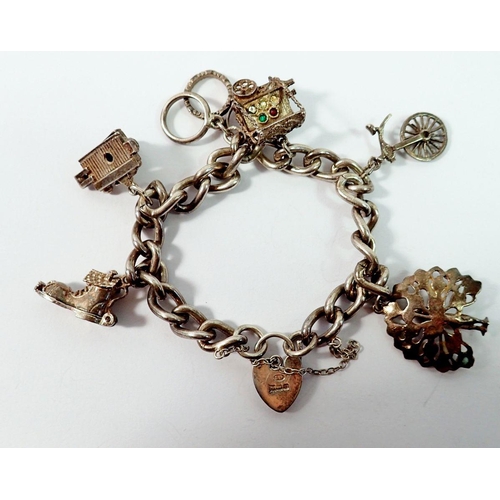 671 - A silver charm bracelet with silver and white metal charms, 48g