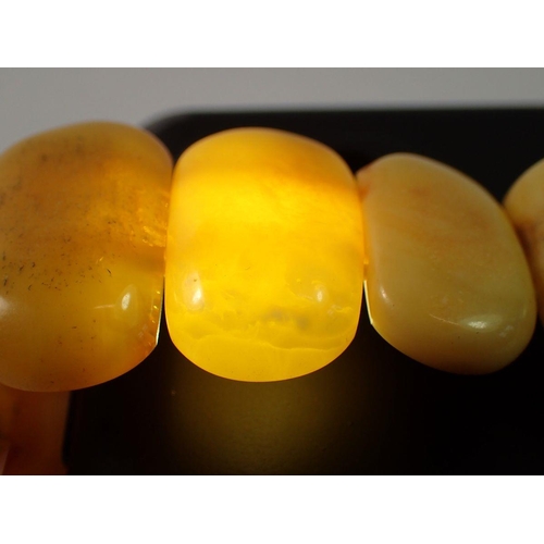 712 - A Baltic amber stretch bracelet, 2.8cm wide, 32g