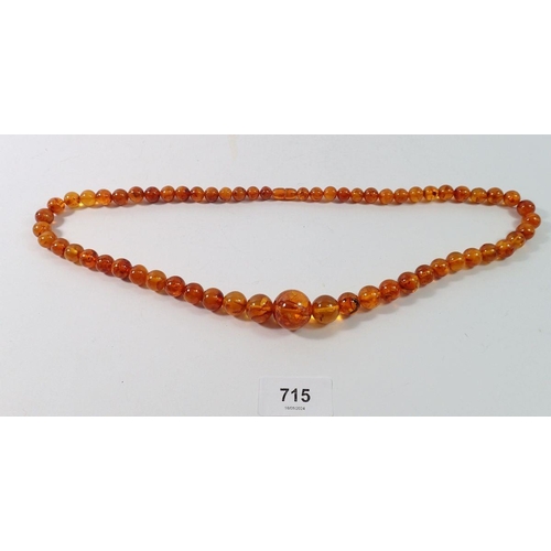 715 - A long amber bead necklace, 68cm long, 60g