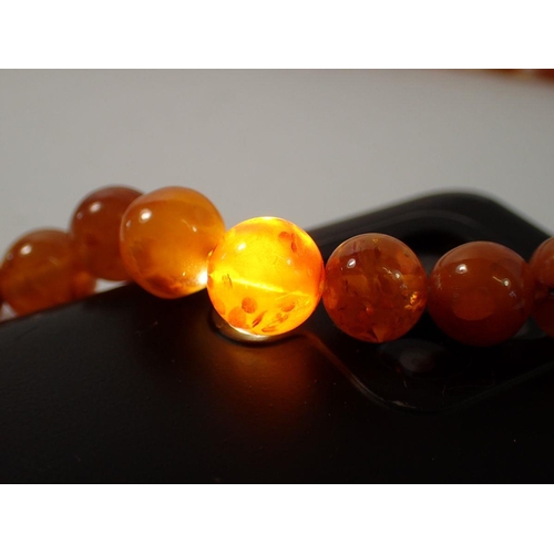 715 - A long amber bead necklace, 68cm long, 60g