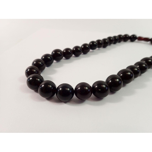 718 - A cherry amber bead necklace, 50cm long, 57g