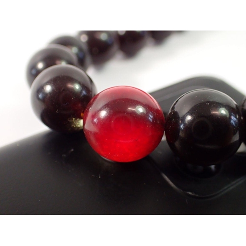 718 - A cherry amber bead necklace, 50cm long, 57g