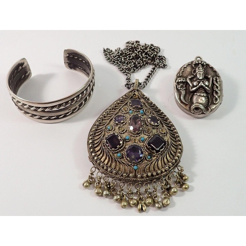 724 - An Indian heavy white metal pendant necklace set coloured stones, a white metal bangle and an Indian... 