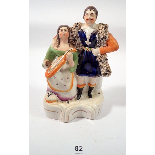 82 - A Victorian Staffordshire group man and child seated with violin, 17cm tall