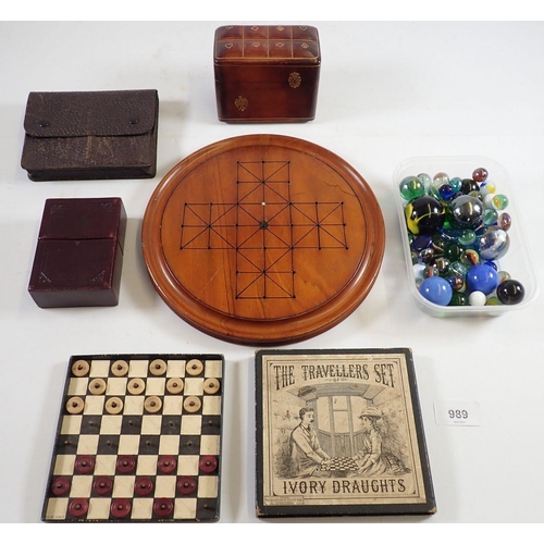 989 - A Victorian boxed travellers set of simulated ivory draughts, a leather playing card box, games boar... 