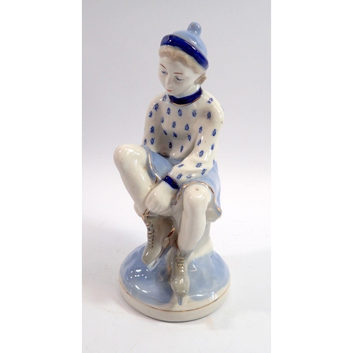 100 - A Russian porcelain figure of a girl putting on ice skates, 23cm tall
