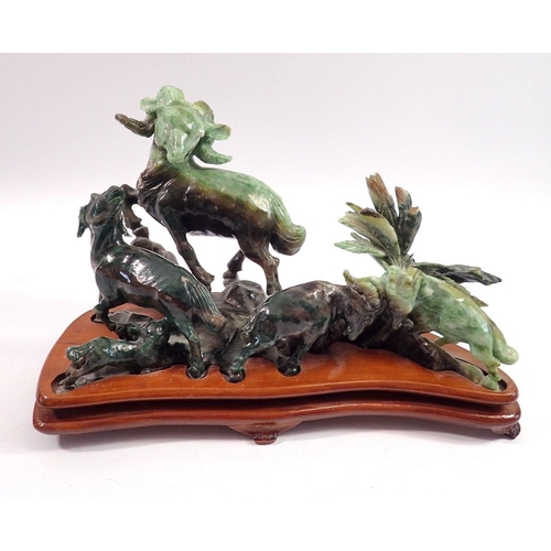 1083 - A Chinese carved green stone group of goats on stand, 29cm wide