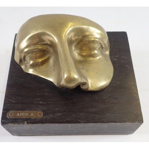 1174 - A Venetian brass face mask mounted on a wooden plinth, 'Aris A' 14 x 12cm