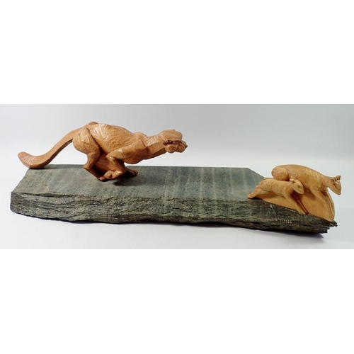 1240 - A large carved wood and stone group of a cheetah chasing an antelope by Dave Johnson (Blaisdon) 71cm... 