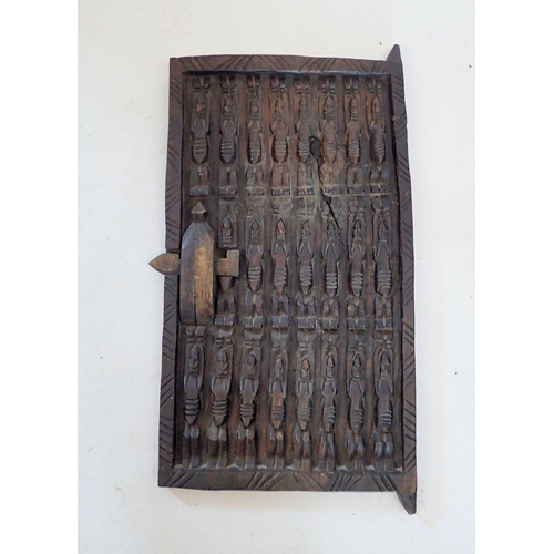 1318 - A carved Dogon tribal door, thought to be from a granary grain store in Mali, decorated three rows o... 