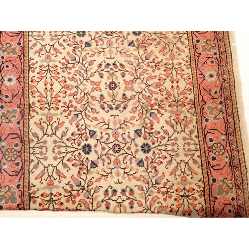 1435 - A small Persian rug with all over floral decoration on a cream ground and pick border, 140 x 73cm